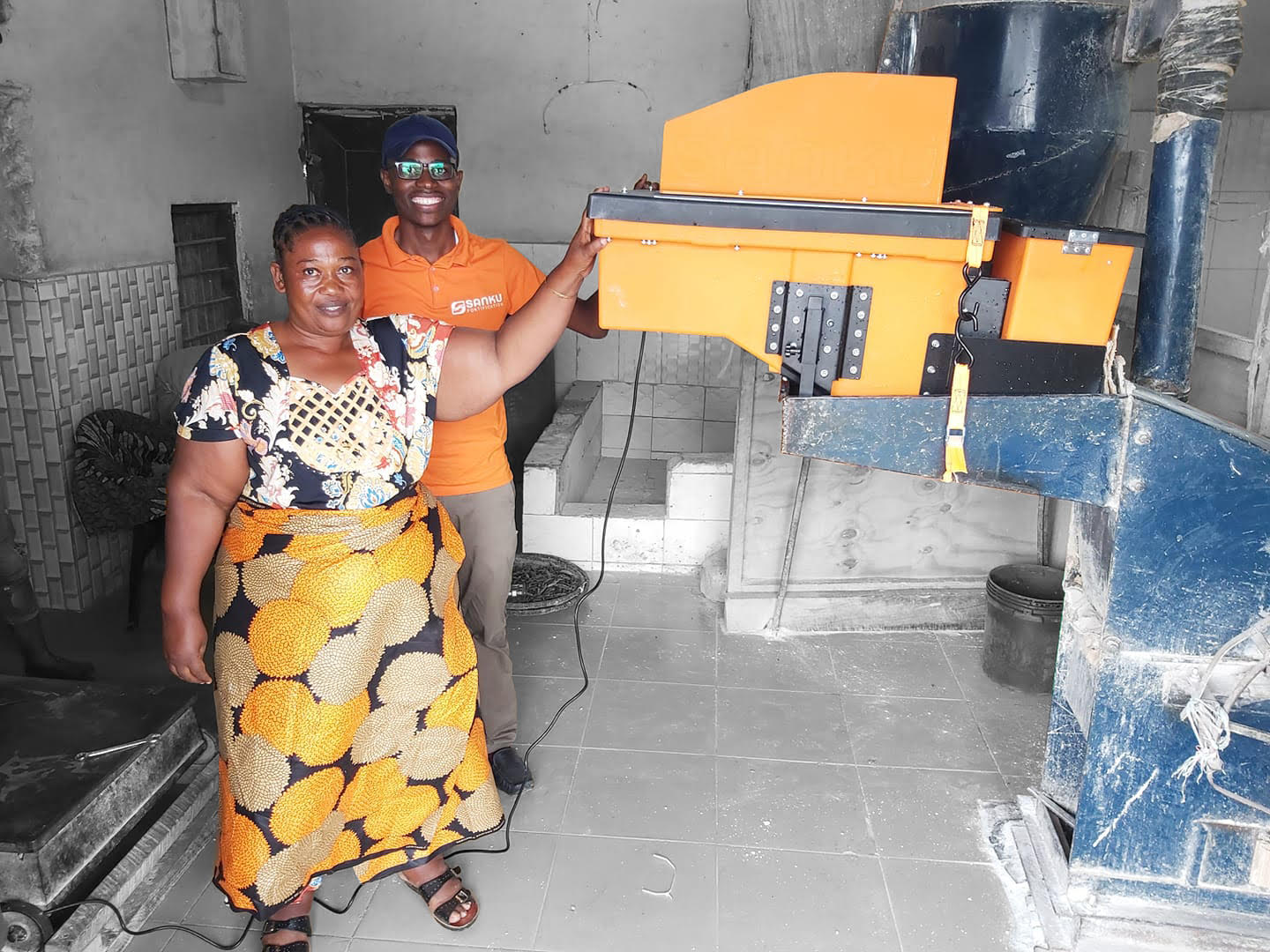 Sanku technician training a miller on the use of the dosifier machine.